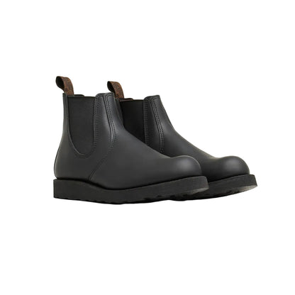 Pair of black Chelsea boots on a light gray background