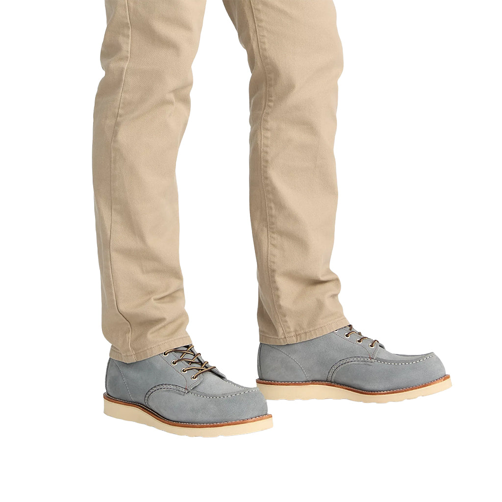 Gray suede shoes worn with beige pants on a white background
