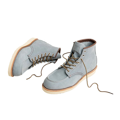 Pair of light blue suede boots with brown laces on a white background