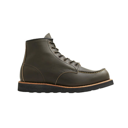 Green leather boot with a black sole on a white background