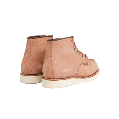 Pair of light pink leather boots with white soles on a white background