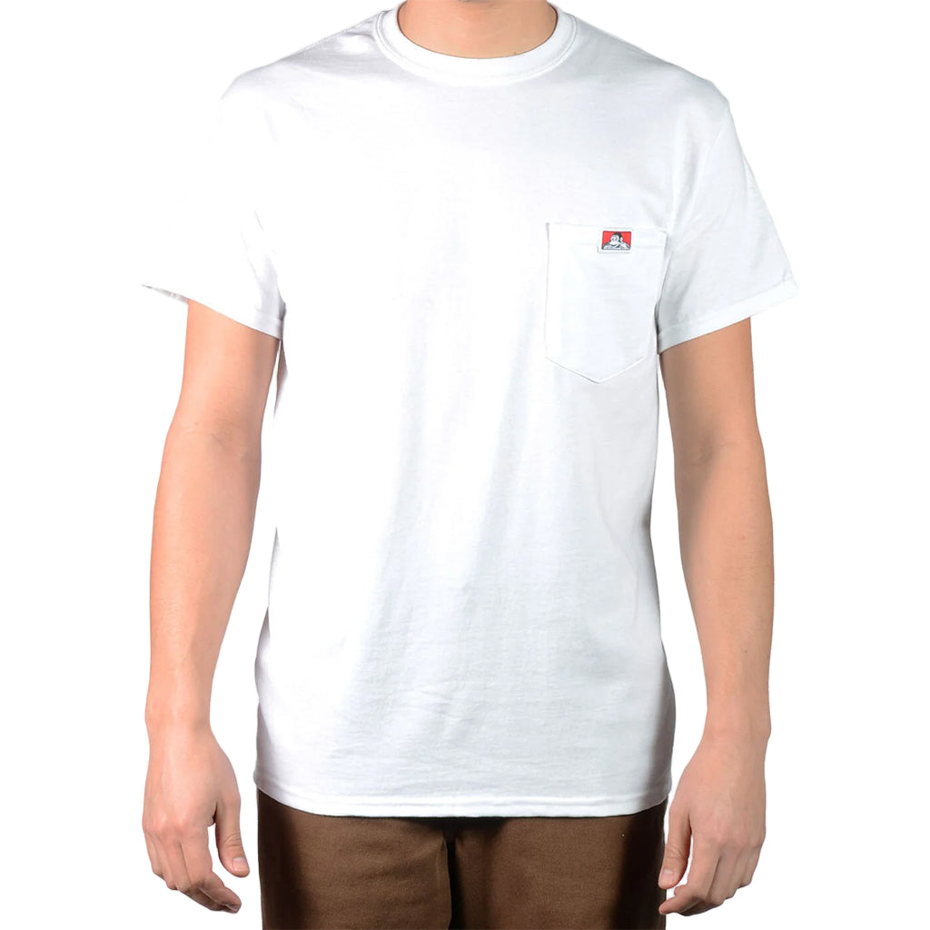 Person wearing a plain white t-shirt with a small logo on a light gray background