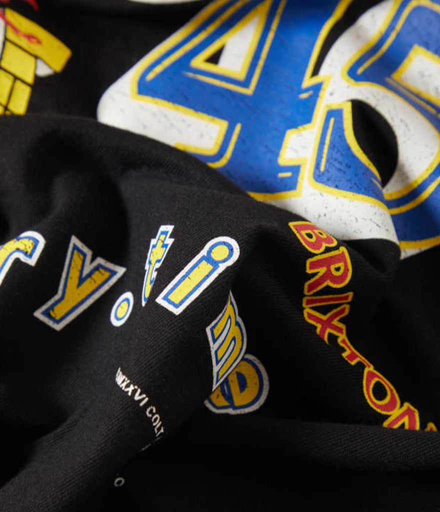 Black jacket with logos and text, including 'Y.I.' and 'Bryton', on a blurred sports jersey background.