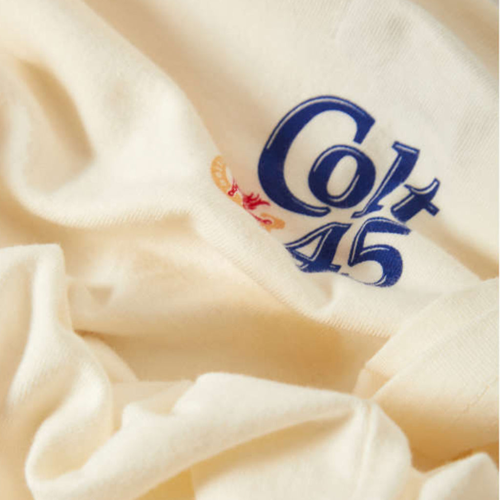 Close-up of a white fabric with 'Colt 45' logo embroidered on it.
