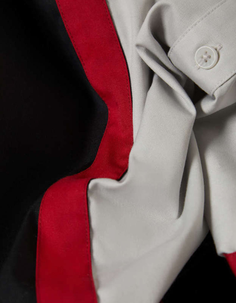 Close-up of a coat with a red stripe and button detail
