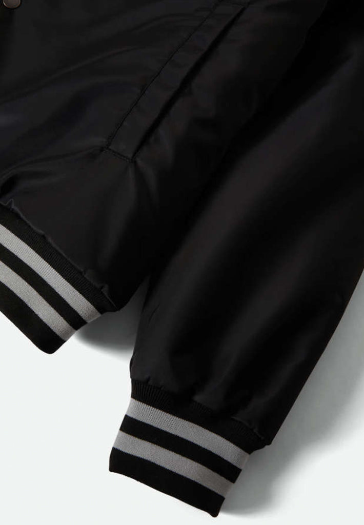 Close up of sleeve cuff and bottom of jacket on a white background