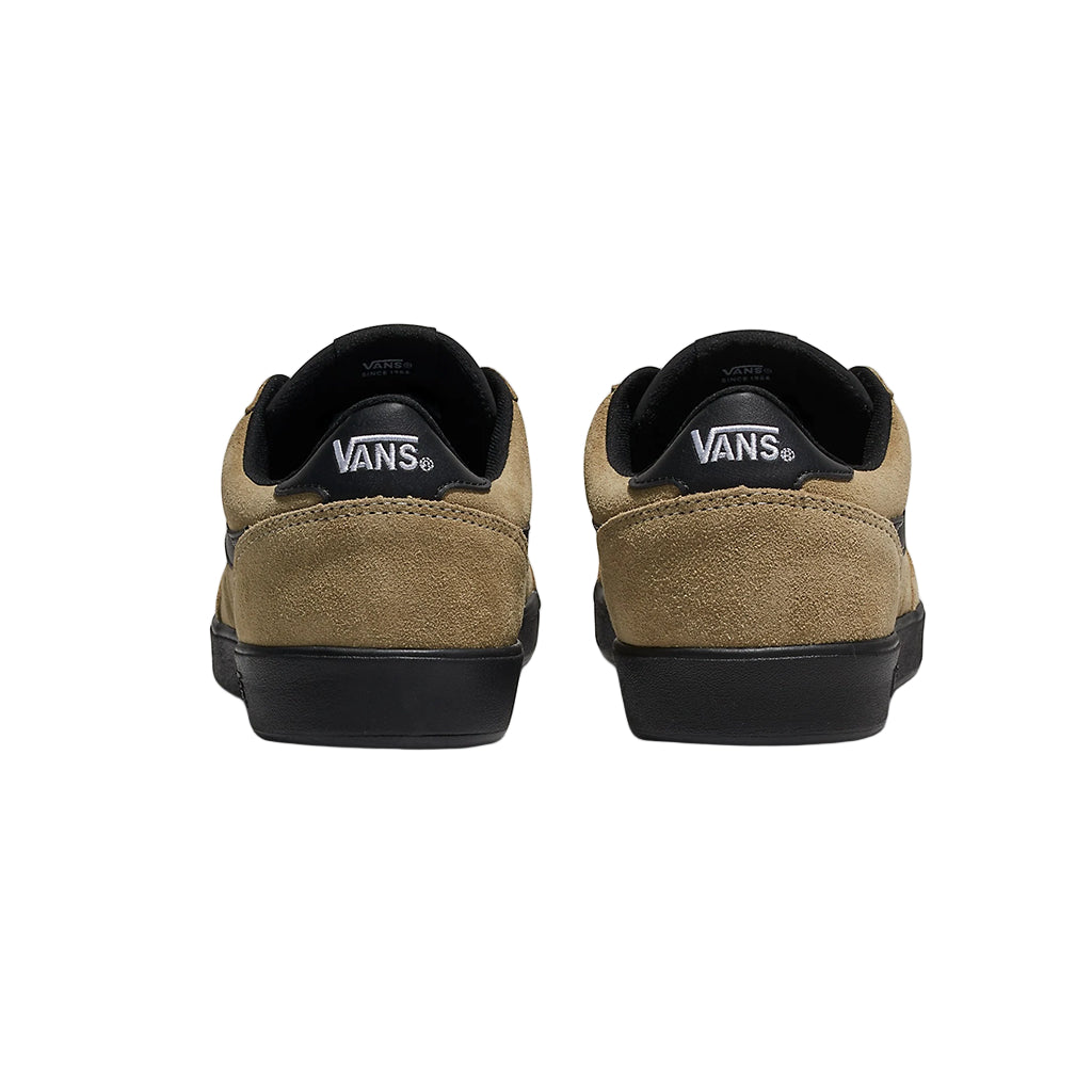 Pair of tan and black Vans shoes on a white background