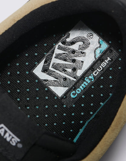 Close-up of a Vans shoe with 'Comfy Cush' label on a black background