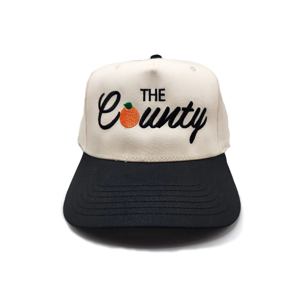 Trucker hat with 'The County' and a pumpkin design on a white background