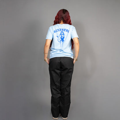 Person wearing a light blue t-shirt with a graphic design on the back, standing against a gray background.