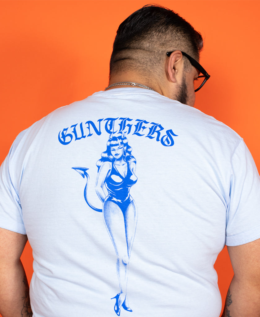 Person wearing a white t-shirt with blue graphics and text on an orange background