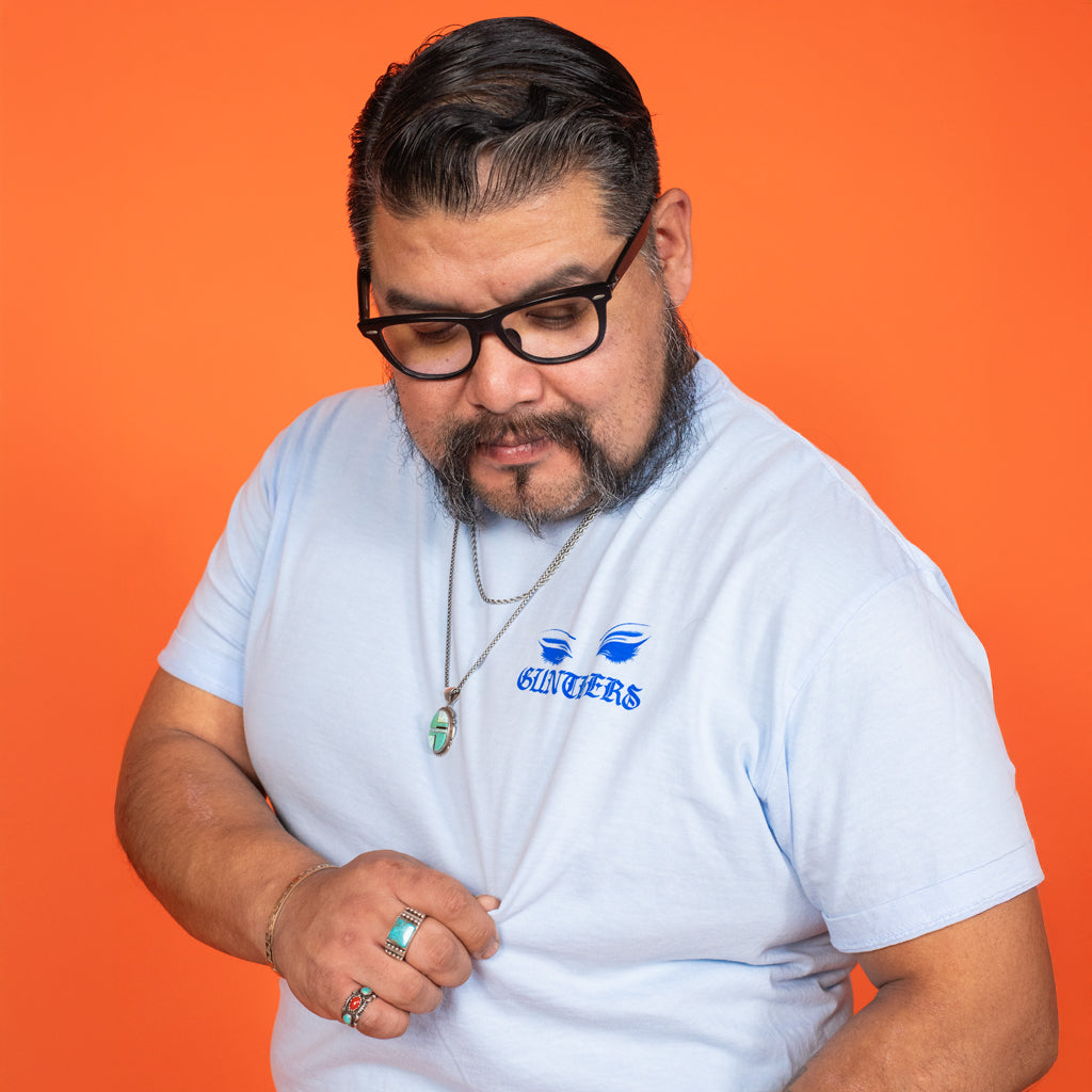 Man wearing a white t-shirt with a logo on an orange background