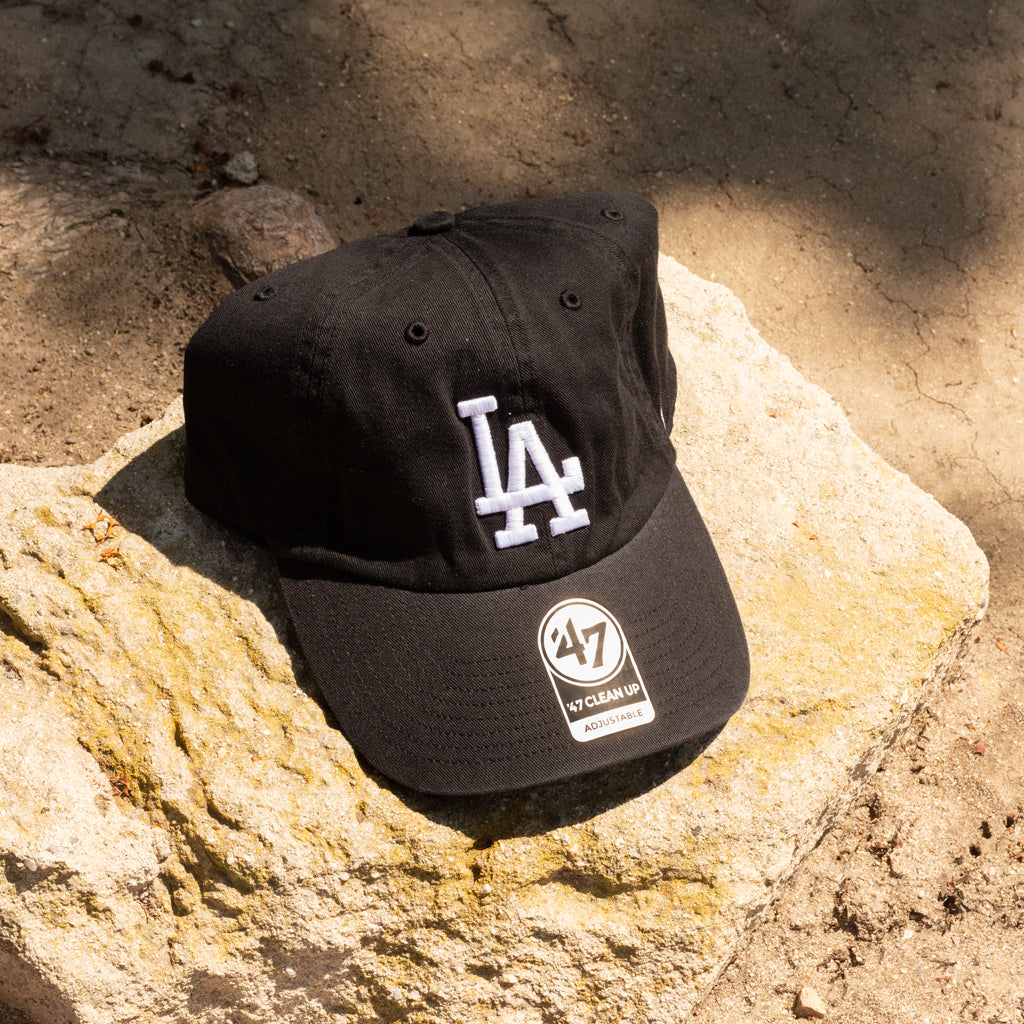 Black cap with LA and 47 brand logos on a rock surface