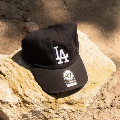 Black cap with LA and 47 brand logos on a rock surface