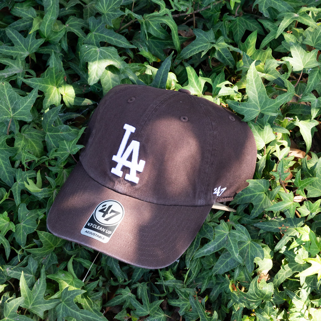 Black baseball cap with LA logo on green leaves