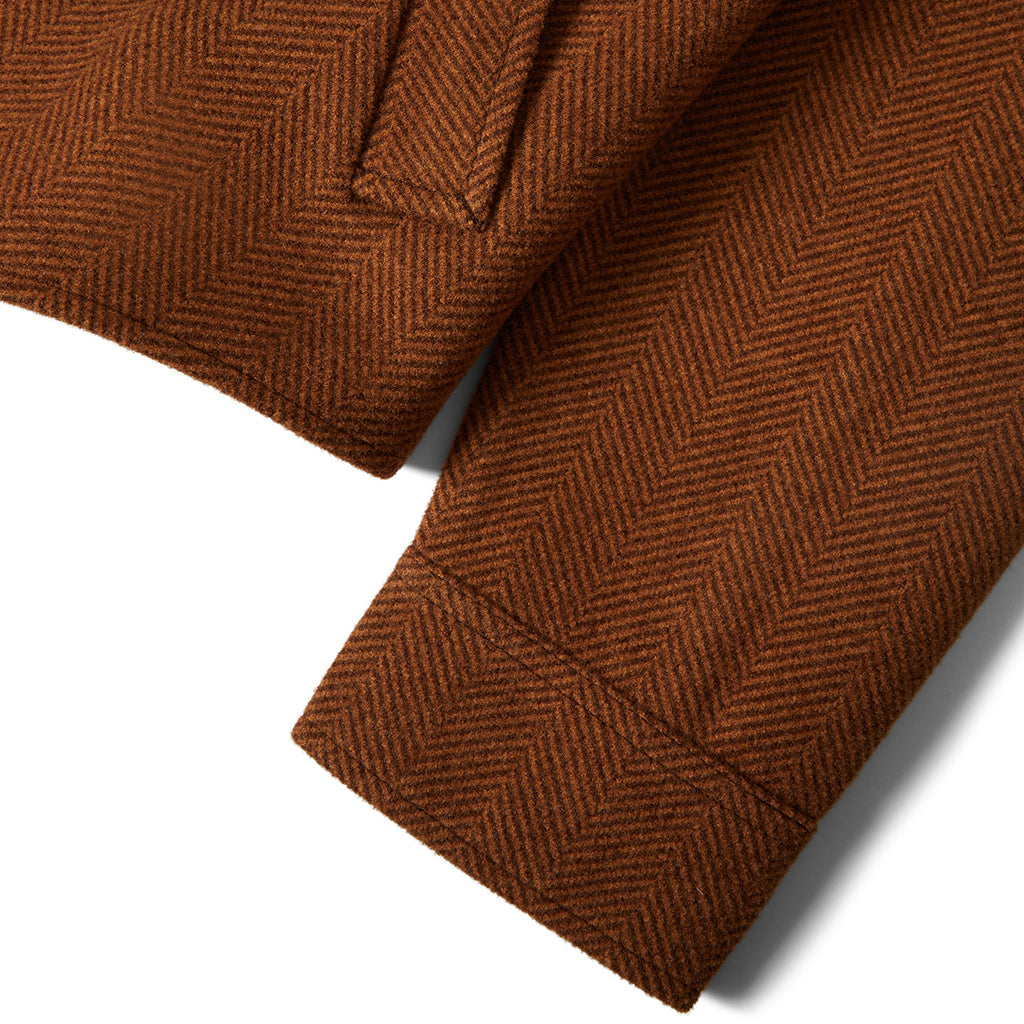 Close-up of brown herringbone fabric on a white background