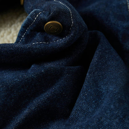 Close-up of a blue fabric with a button, possibly from a coat or jacket.