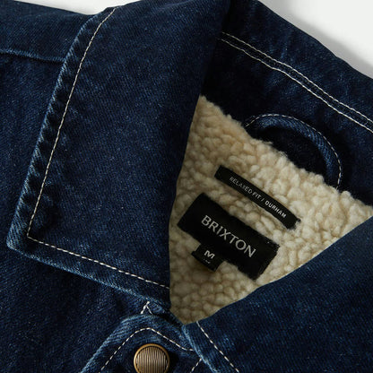 Close-up of a denim jacket with Brixton branding on a white background