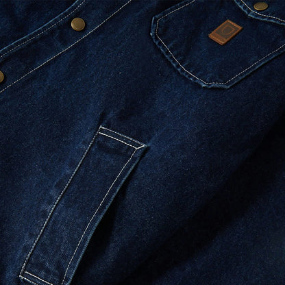 Close-up of a blue denim jacket with a brand logo on the chest pocket.