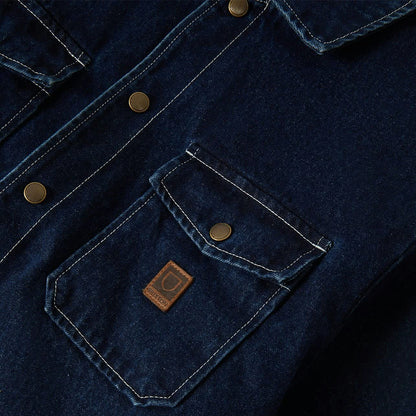 Close-up of a dark blue denim jacket with a brand logo on the pocket.