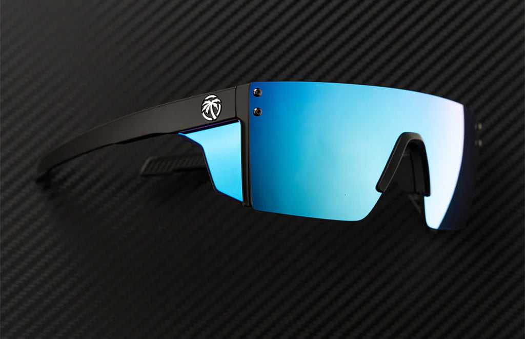 Sunglasses with blue lenses and black frame on a carbon fiber background