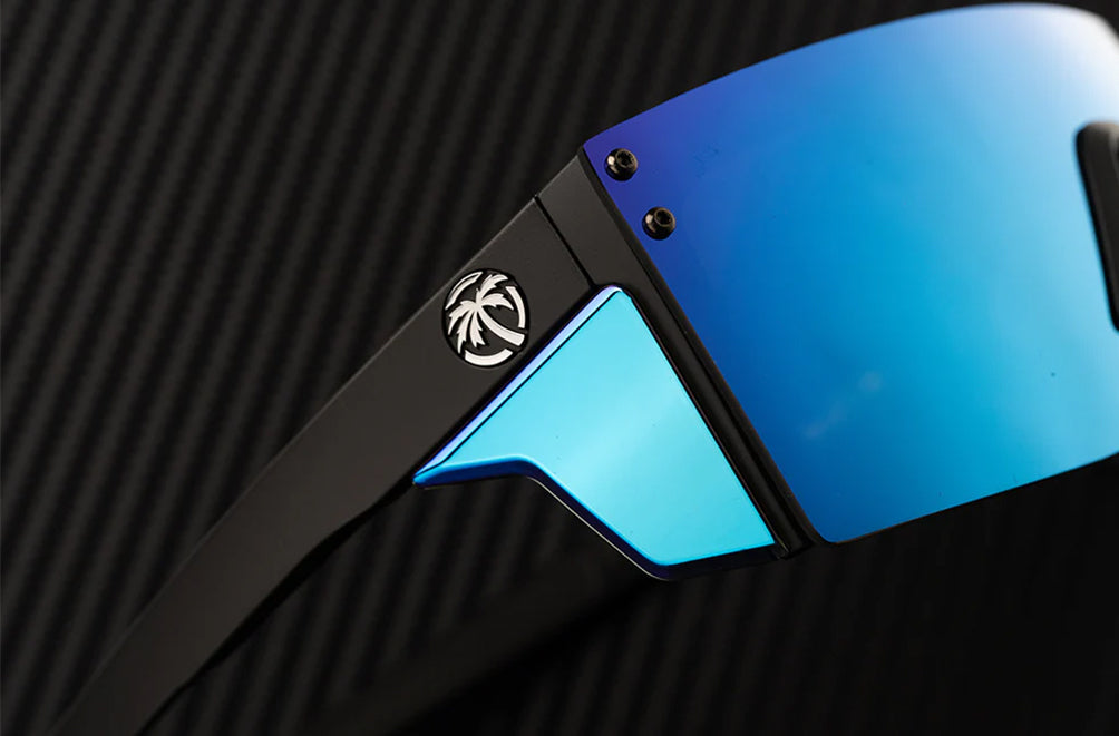 Close-up of a pair of sunglasses with blue reflective lenses and black frame on a dark textured background.