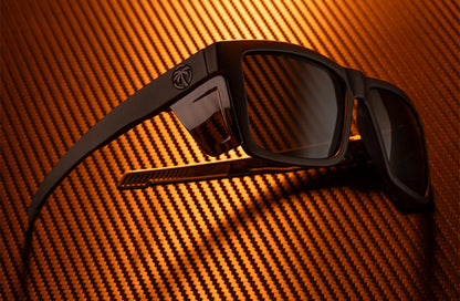 Black sunglasses with a reflective surface on an orange textured background