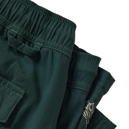Dark green pants with a close-up of the waistband and pocket on a white background