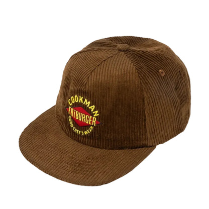 A brown corduroy baseball cap with a curved brim, featuring a red and yellow embroidered 'Cookman Hamburger' logo on the front. 