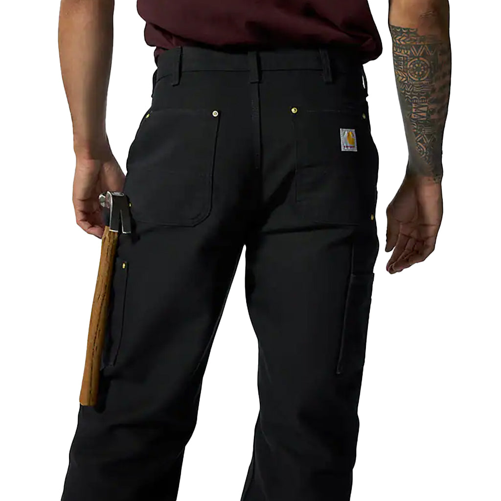 Person wearing black pants with a visible brand logo, holding a rifle.