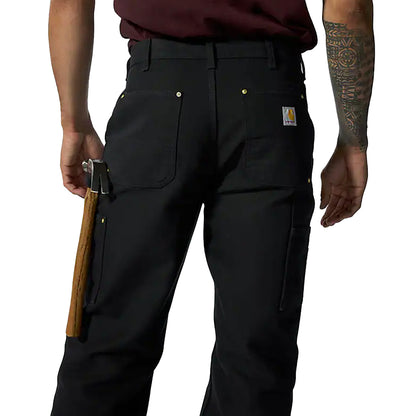 Person wearing black pants with a visible brand logo, holding a rifle.