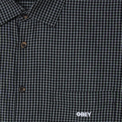 Close-up of a black and white checkered shirt with 'Obey' logo.
