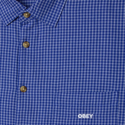 Close-up of a blue checkered shirt with 'Obey' logo