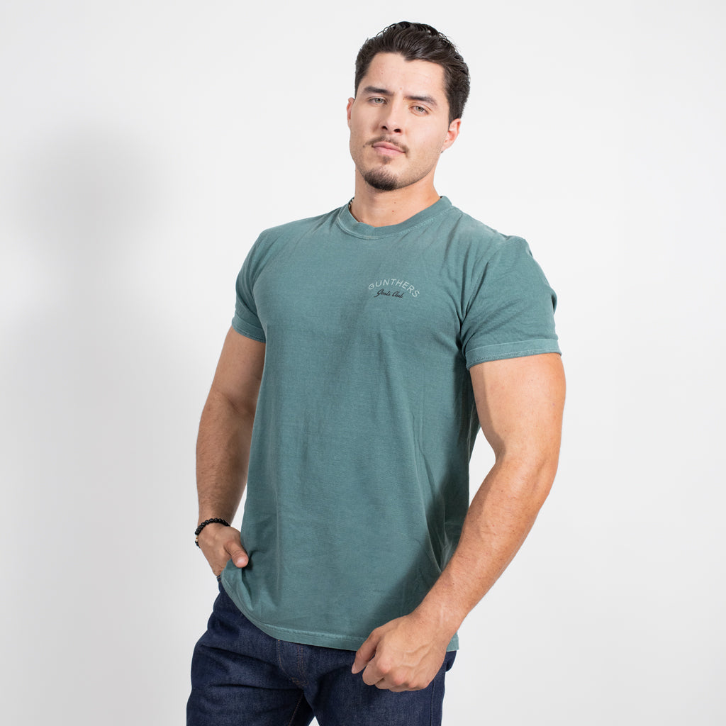 Man wearing a green t-shirt with a logo on a white background