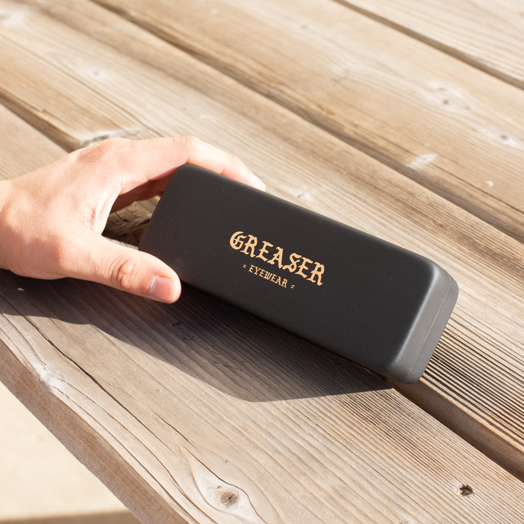 Greaser sunglasses case being held up. 