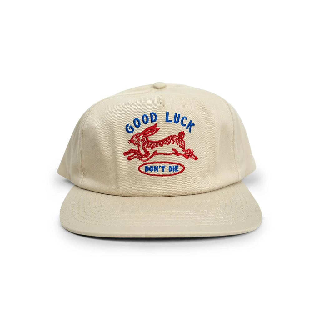 Beige cap with 'Good Luck Don't Die' text and graphic on a white background