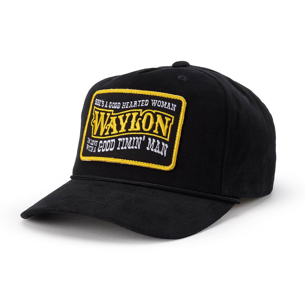 A black baseball cap featuring a rectangular embroidered patch on the front with the text 'WAYLON' in yellow and white text surrounding it.