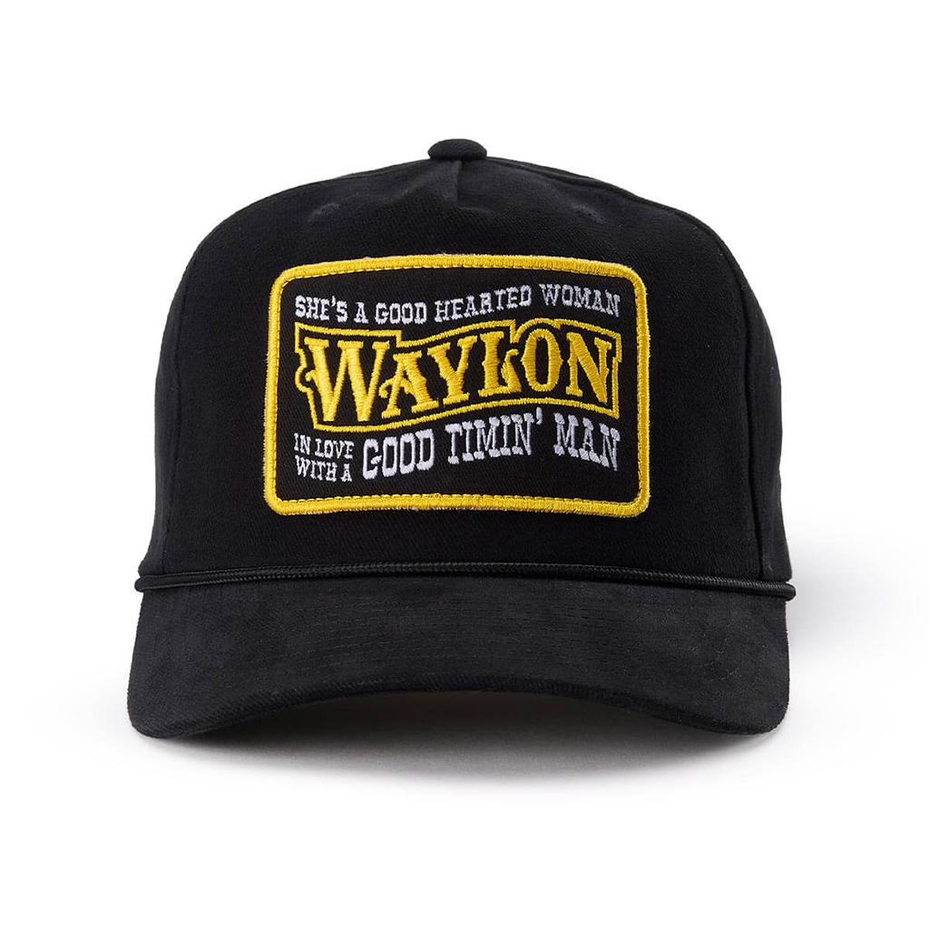 A black baseball cap featuring a rectangular embroidered patch on the front with the text 'WAYLON' in yellow and white surrounding text, photographed on a clean white background.