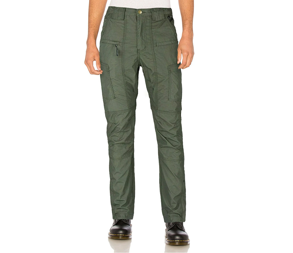 Green cargo pants worn by a person on a white background