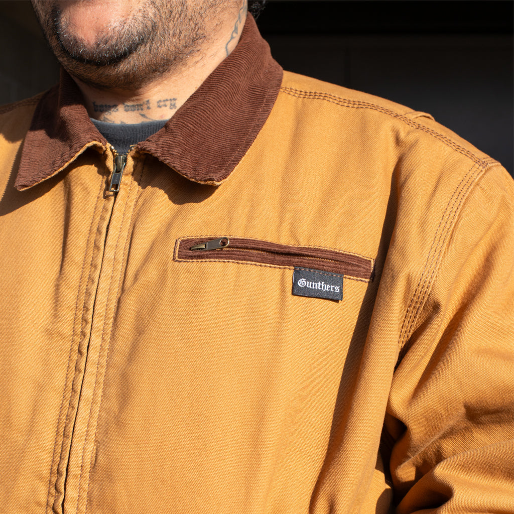 Brown jacket with a Gunthers Logo on a dark background