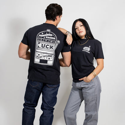 Two people wearing black t-shirts with text and graphics on a plain background