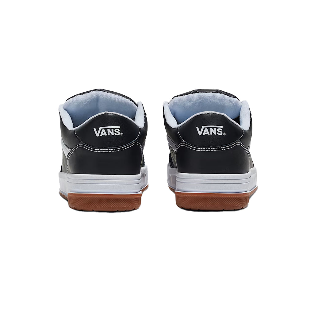 Black Vans sneakers with white soles and brown soles on a white background
