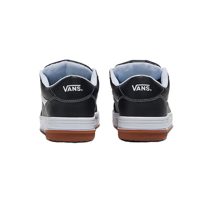 Black Vans sneakers with white soles and brown soles on a white background