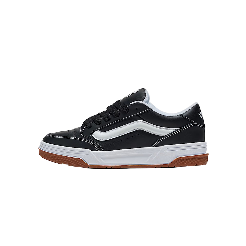 Black and white sneaker with brown sole on a light gray background