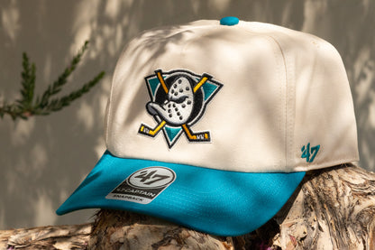 Beige and blue cap with a logo on a wooden surface
