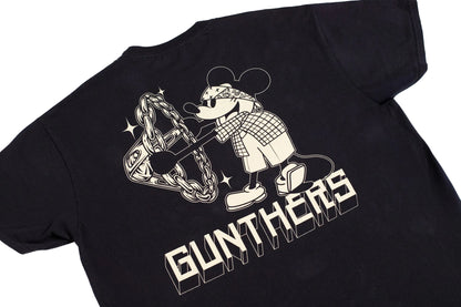 A black short-sleeve t-shirt laid flat on a white background, featuring a large graphic print of a cartoon mouse character wearing sunglasses and a plaid shirt, holding a chain, with the word 'GUNTHERS' in bold block letters below.