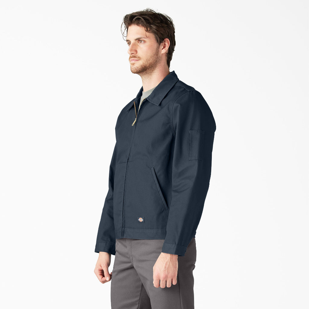 Man wearing a navy jacket and gray pants on a white background