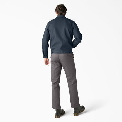 Man wearing a navy jacket and gray pants on a white background