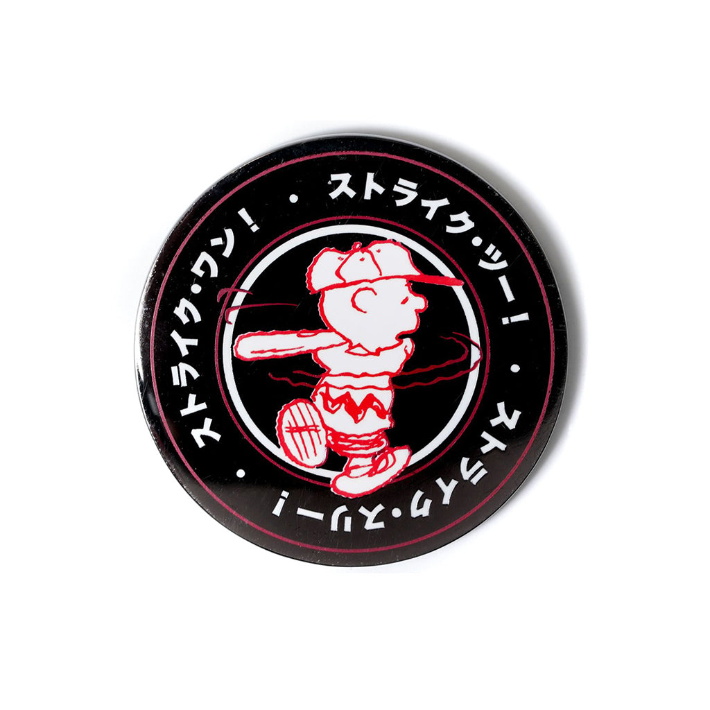 Circular pin with charlie brown and Japanese text on a white background
