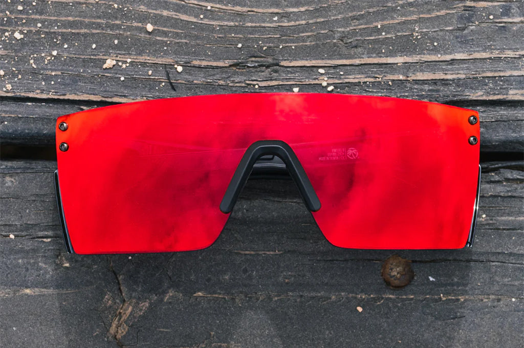 Red sunglasses with a black frame on a wooden surface